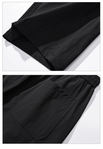 Detail of black breathable street pants showing elastic waist pleats and side patch pocket