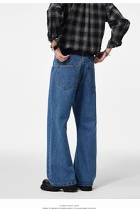 Rear side view showing the drape and silhouette of men's deep blue wide-leg denim jeans