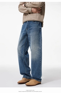 Detailed macro view of light blue washed denim fabric and loose fit hem on men's jeans