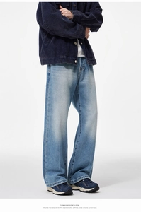 Detailed view of vintage washed blue wide-leg jeans with whiskering and faded finish