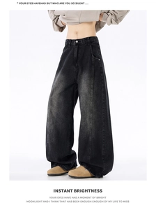Detailed close-up of vintage washed dark gray baggy jeans with deconstructed seams