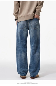 Back view of light blue loose straight-leg washed jeans styled with brown work boots