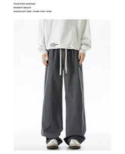Detail of men's dark grey loose fit trousers with elastic drawstring waistband and straight cut
