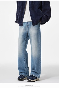 Detail of light blue washed men's flared denim jeans paired with corduroy jacket
