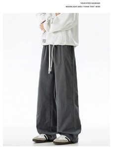 Detail view of washed dark grey oversized cotton trousers with elastic drawstring waist