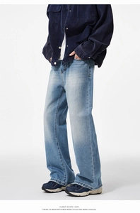 Detail of light blue washed denim jeans with vintage faded texture and loose fit style
