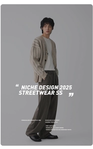 Detaillierte Ansicht der beige Strickjacke und der grau gestreiften Weithosen-Kombi