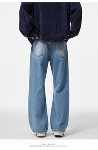 Rear view of corduroy jacket and baggy washed jeans in a minimalist streetwear look
