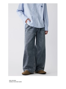 Detail einer Vintage-Wide-Leg-Jeans kombiniert mit einem blauen Hemd mit Herz-Patch