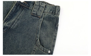 Detail of vintage washed denim jeans featuring elastic waist and reinforced metal rivets