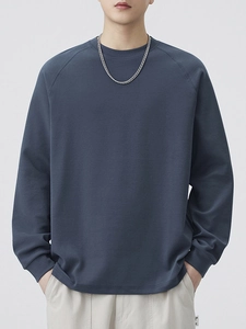Deep blue-grey long sleeve raglan crewneck sweatshirt in a relaxed minimalist style