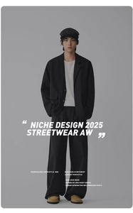 Detail of minimalist black streetwear suit set with wide-leg trousers and a stylish blazer