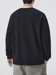 Back view of a men's black raglan sleeve sweatshirt with a minimalist crew neck design