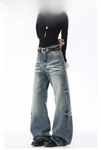Dettaglio del lavaggio denim vintage con baffi e cintura con borchie sul pantalone