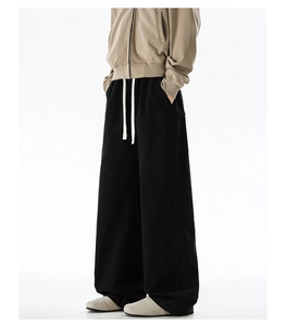 Detail of black cotton oversized straight trousers with contrasting cream drawstring waist
