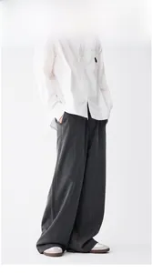 Detailed view of dark grey striped wide-leg trousers with premium draping texture