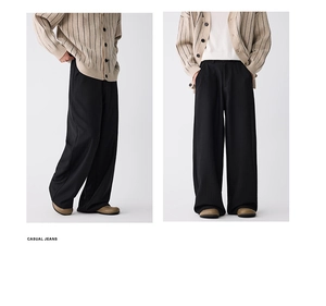 Detail der schwarzen weiten Hose mit lockerer Passform und feiner vertikaler Textur