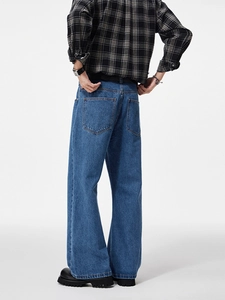 Men's loose baggy straight-leg jeans in dark blue denim from a back-diagonal view