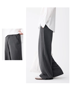 Detail of grey textured striped wide-leg trousers showing drape and relaxed fit
