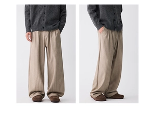 Detail der hellbeige Plisseehose mit vertikaler Textur und lockerem weitem Beinschnitt