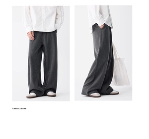 Close-up of dark grey wide-leg trousers featuring vertical textured stripes and premium drape