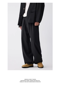 Detailed view of black striped loose fit trousers with draped texture and American style