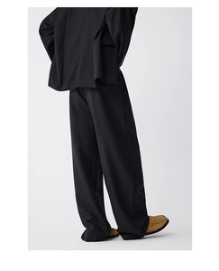 Detail view of black pinstripe wide-leg trousers with elegant drape and relaxed fit