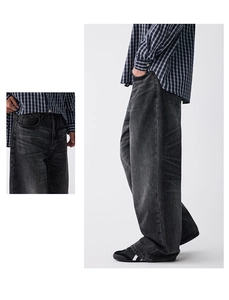 Gros plan sur l'effet délavé vintage et la texture du jean large gris pour hommes