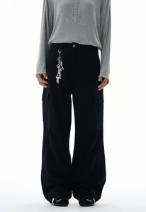 Detail shot of black cotton baggy cargo pants with side pockets and metal key accents