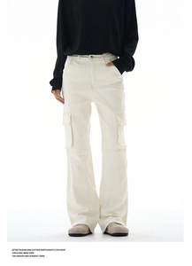 Detail view of cream cargo pants showing large side pockets and reinforced stitching