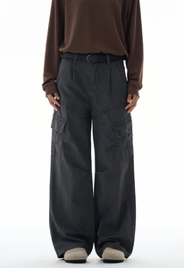 Detail shot of charcoal gray wide-leg cargo pants with side flap pockets and a black belt