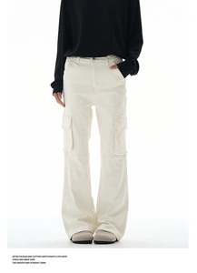 Detailed view of cream cargo pants featuring side flap pockets and knee seam stitching