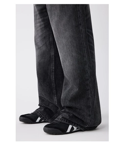 Vue détaillée de la texture denim gris avec moustaches et effet de lavage sur le jean