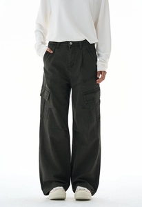 Detail view of baggy cargo pants with large side flap pockets and washed vintage texture