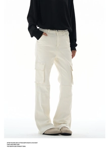 Detail view of cream cargo pants featuring large side flap pockets and premium stitching