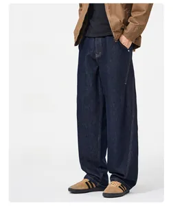 Detail view of baggy deep blue denim pants featuring contrast yellow stitching and relaxed fit