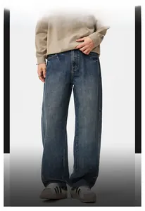 Dettaglio dei jeans larghi da uomo con lavaggio vintage e texture con baffature