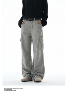 Detail of gray baggy cargo pants featuring oversized side pockets and contrast stitching