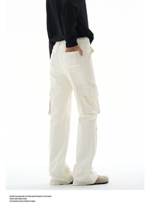 Detail view of cream cargo pants featuring functional flap pockets and durable cotton twill
