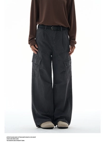 Detail of loose fit dark grey cargo pants with side flap pockets and black belt