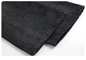 Gros plan détaillé de l'ourlet à double surpiqûre d'un jean évasé gris délavé