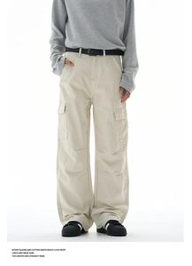 Close-up detail of beige baggy cargo pants with side pockets and twill fabric texture