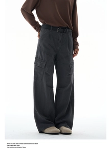 Detail of dark grey cargo pants with large side pockets and thin black waist belt