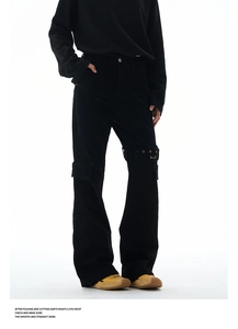 Detail of black street style cargo pants featuring metal buckle straps and utility pockets
