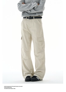 Detail of baggy cargo pants featuring knee pleats and side flap pockets in khaki twill