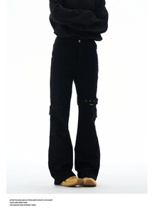 Detailed close-up of black cargo pants featuring metal buckle strap and flap pockets texture