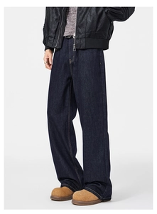 Dettaglio macro dei jeans blu scuro a gamba larga con cuciture gialle a contrasto