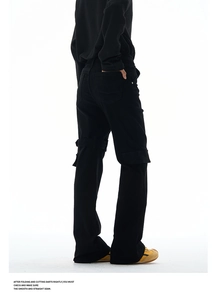 Detail of black flare cargo jeans featuring adjustable straps and tactical utility pockets