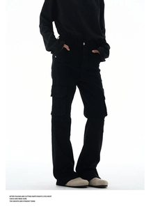 Detail view of black cargo pants featuring flap side pockets and stitched knee panels