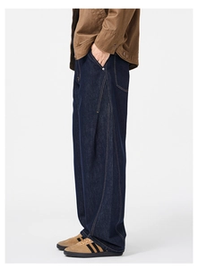 Detail view of deep blue wide-leg jeans with curved side stitching and contrast seam lines